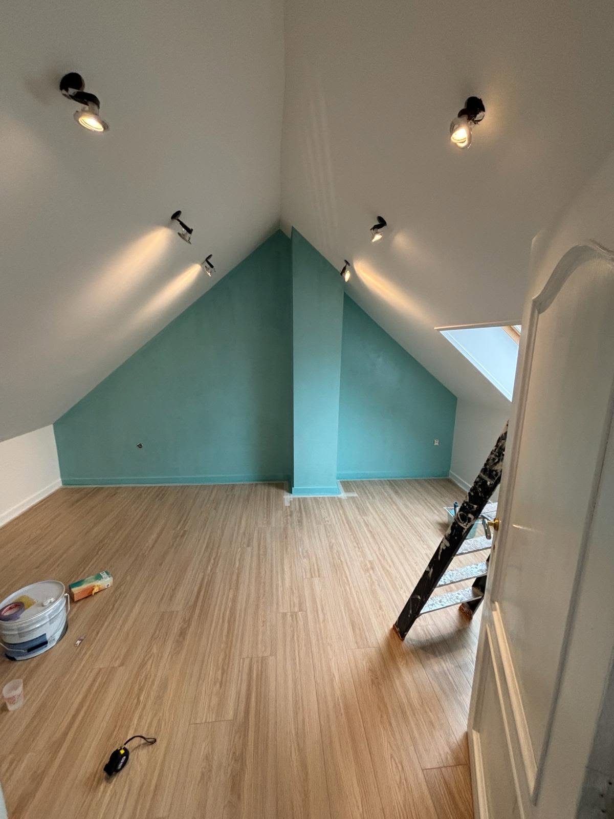 Combles peints en blanc avec mur d’accent bleu turquoise