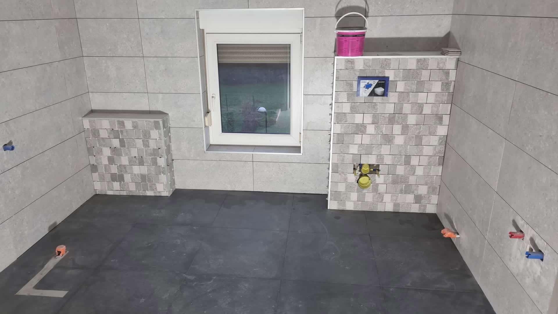 Pose du carrelage gris dans la salle de bain